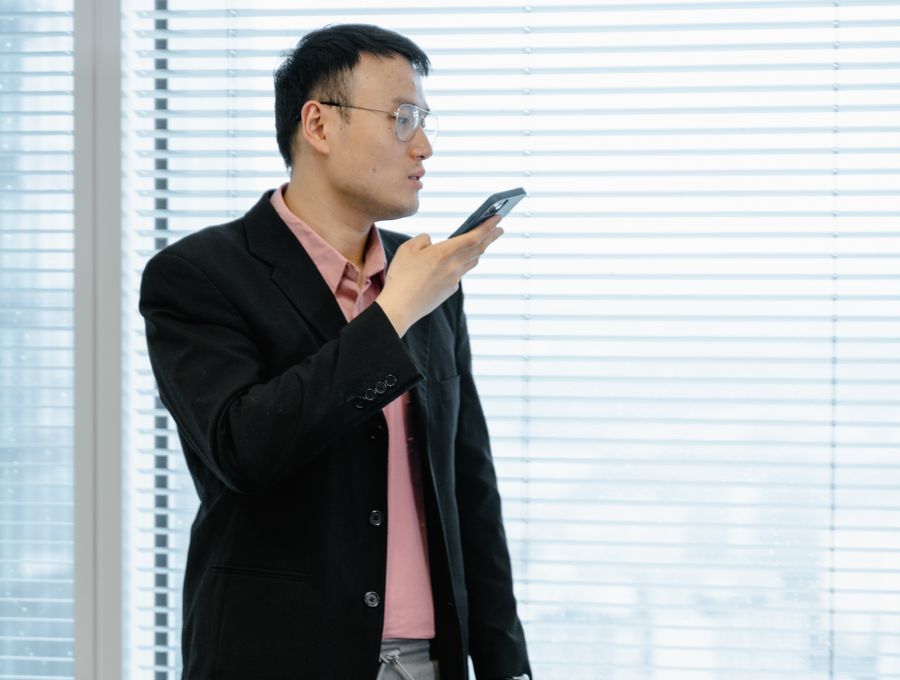 A man using his phone in a bright office